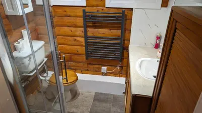 a small bathroom with a toilet and a sink at Snowdonia Log Cabin 2 in Trawsfynydd