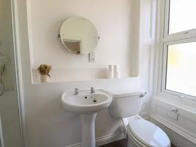 a white bathroom with a toilet and a sink at Serenity House, The Retreat in Llangammarch Wells