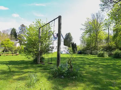 a swing set in a field in front of a house at Serenity House, The Retreat in Llangammarch Wells