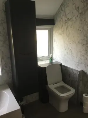 a bathroom with a toilet and a window and a sink at Harbour House in Barmouth