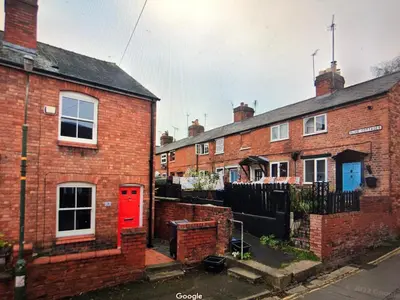 a row of brick houses with a red door at Simply Shrewsbury, by Severn Theatre & Quarry Park in Shrewsbury