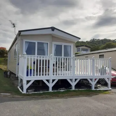 a tiny house with a porch and a white railing at 2 Bed Chalet - Sleeps 4 - Pets - Parking in New Quay