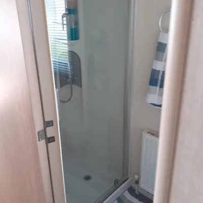 a bathroom with a shower with a glass door at 2 Bed Chalet - Sleeps 4 - Pets - Parking in New Quay