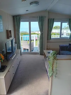 a living room with a couch and a television at 2 Bed Chalet - Sleeps 4 - Pets - Parking in New Quay