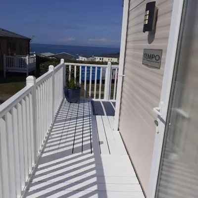 a porch of a house with a white fence at 2 Bed Chalet - Sleeps 4 - Pets - Parking in New Quay