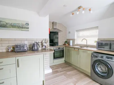 a kitchen with a washing machine and a washer at 2 Penporth in Rhayader