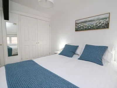 a bedroom with a large white bed with blue pillows at 1 Penporth in Rhayader