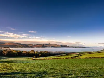 a foggy field with a lake in the background at 1 Bed in Talybont-on-Usk oc-a29348 in Talybont