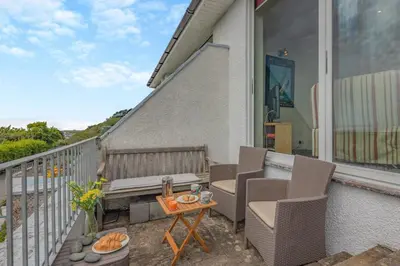a patio with two chairs and a table on a balcony at 3 Bed in Aberdovey oc-v29263 in Aberdyfi