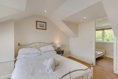 a bedroom with a white bed and a window at 3 Bed in Aberdovey oc-v29263 in Aberdyfi