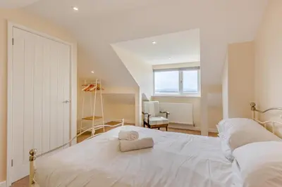 a bedroom with a white bed with a towel on it at 3 Bed in Aberdovey oc-v29263 in Aberdyfi