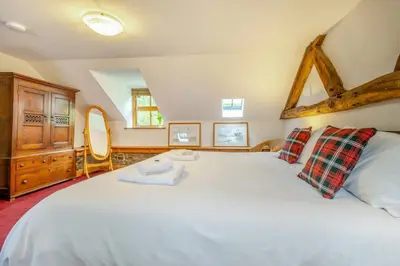 a bedroom with a large white bed and a wooden dresser at 2 Bed in Knighton oc-t29330 in Felindre