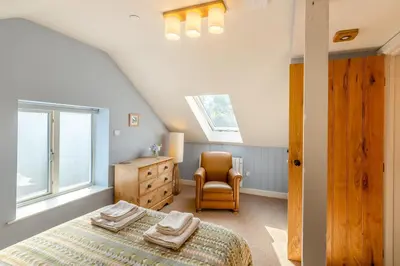 a bedroom with a bed and a chair and a window at 1 Bed in Craven Arms oc-o29275 in Craven Arms