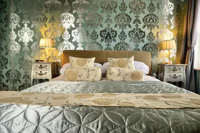 a bedroom with a large bed with two night stands at The Hotel Commodore in Llandrindod Wells