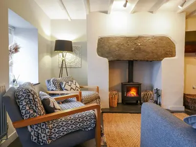 a living room with a fireplace and a couch at Ty Dyffryn in Blaenau-Ffestiniog