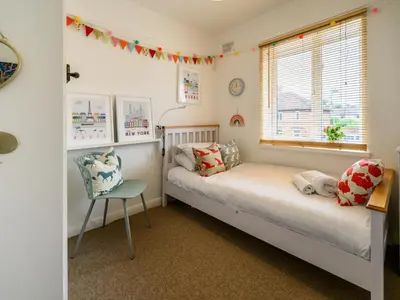a bedroom with two twin beds and a chair at 3 Bedroom home within walking distance of town - Pass the Keys in Shrewsbury