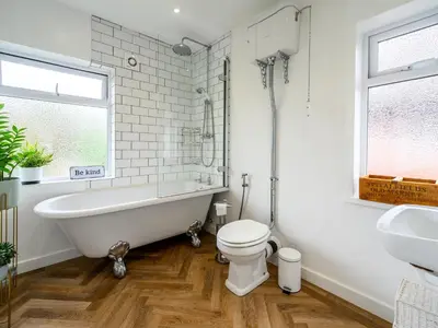 a bathroom with a tub and a toilet and a sink at 3 Bedroom home within walking distance of town - Pass the Keys in Shrewsbury