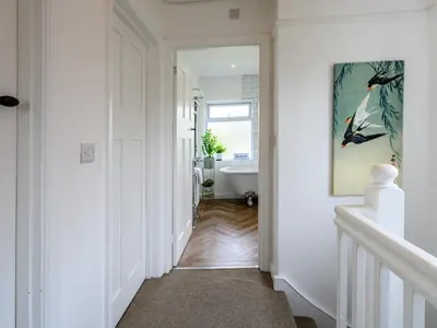 a hallway with a bathroom with a tub and a sink at 3 Bedroom home within walking distance of town - Pass the Keys in Shrewsbury