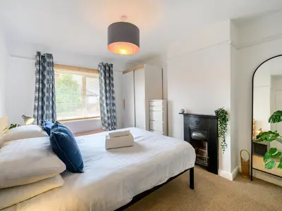 a bedroom with a bed with a mirror and a fireplace at 3 Bedroom home within walking distance of town - Pass the Keys in Shrewsbury