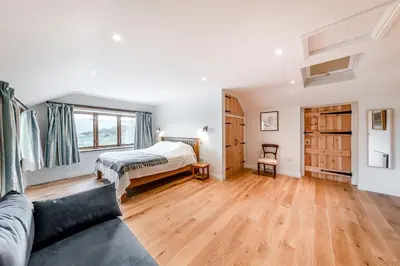 a living room with a bed and a couch at 4 Bed in Derwenlas oc-c29244 in Machynlleth