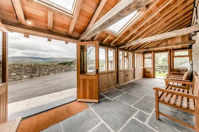 an empty room with a wooden door and windows at 4 Bed in Derwenlas oc-c29244 in Machynlleth
