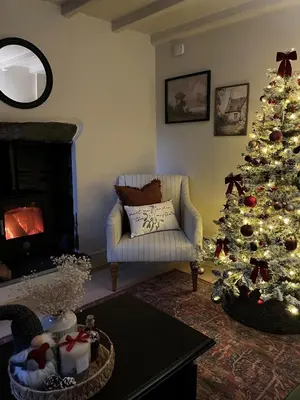 a living room with a christmas tree and a couch at Poets Cottage Eglwys Fach in Scyborycoed