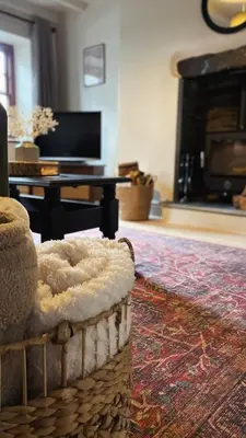 a living room with a couch and a fireplace at Poets Cottage Eglwys Fach in Scyborycoed