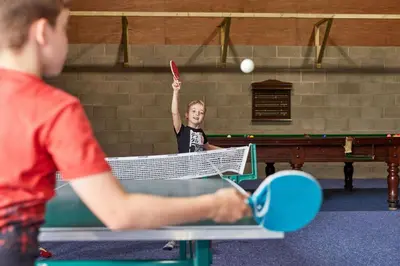 a young girl hitting a tennis ball with a racket at Toad Hall in Church Stretton