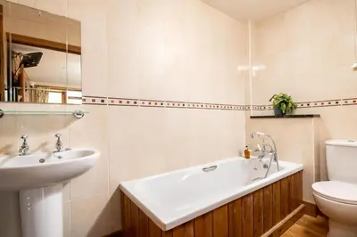 a bathroom with a sink and a tub and a toilet at Toad Hall in Church Stretton