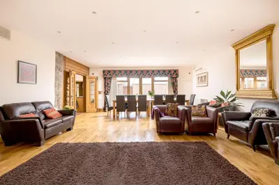 a living room with leather furniture and a dining room at Toad Hall in Church Stretton