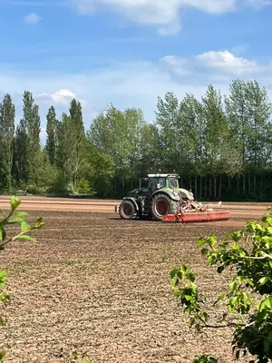 a tractor is parked in a field at Lilac Cottage in Stoke Prior