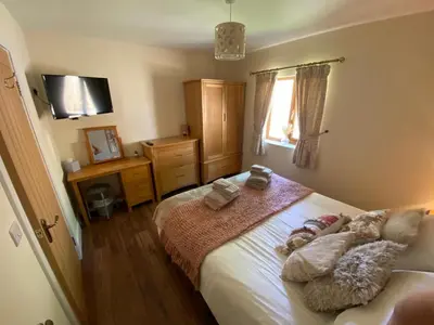 a bedroom with a bed with three pillows on it at Lilac Cottage in Stoke Prior