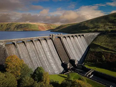 a dam with water spilling over a lake at Ty Ray Penmaes in Rhayader