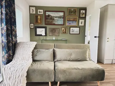 a couch in a living room with pictures on the wall at Ty Ray Penmaes in Rhayader