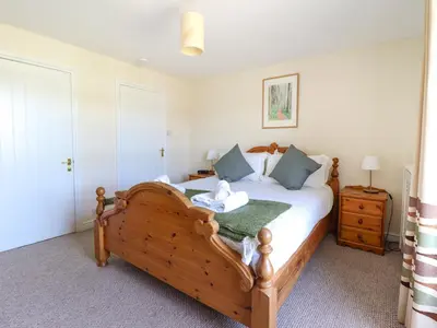 a bedroom with a large wooden bed with blue pillows at Glasfryn in Dolgellau