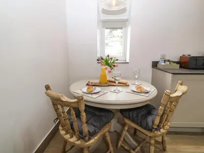 a dining room table with two glasses of wine at Y Stabl in Dyffryn