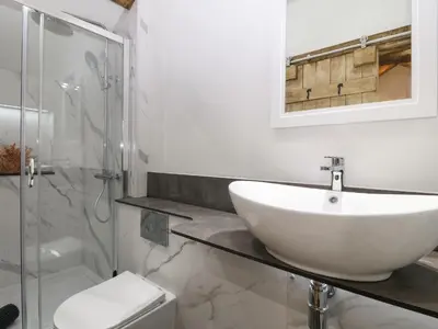 a white bathroom with a sink and a shower at Y Stabl in Dyffryn