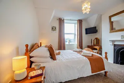 a bedroom with a large bed and a fireplace at 3 Bed in Llanbedr oc-t28932 in Llanbedr