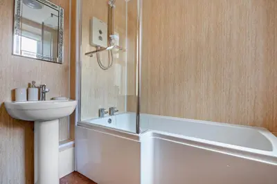 a bathroom with a white tub and a sink at 3 Bed in Llanbedr oc-t28932 in Llanbedr