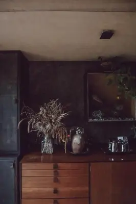 a vase of flowers on top of a wooden dresser at Two unique cabins wrapped in beautiful welsh scenery in Presteigne