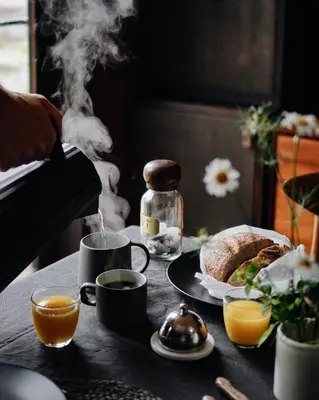a table with a breakfast of coffee and a plate of food at Two unique cabins wrapped in beautiful welsh scenery in Presteigne