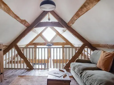 a living room with a couch and a large window at Hayloft Barn in Clifford