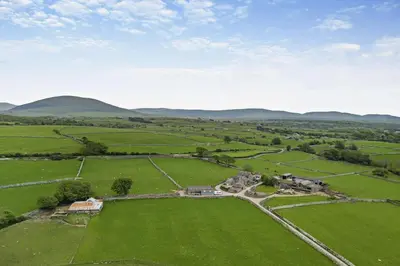 an aerial view of a farm with mountains in the background at 1 Bed in Dyffryn Ardudwy oc-g29349 in Dyffryn