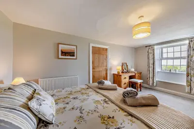 a bedroom with a large bed and a window at 3 Bed in Dyffryn Ardudwy oc-f29350 in Dyffryn