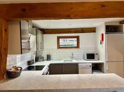 a kitchen with a sink and a refrigerator at Serafina Cottage in Leominster