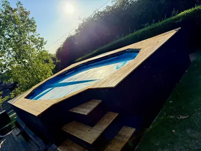 a swimming pool on top of a house with stairs at Serafina Lodge in Leominster