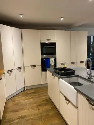 a kitchen with white cabinets and a stove top oven at The chapel in Machynlleth