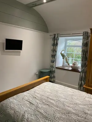 a bedroom with a bed and a window at The chapel in Machynlleth