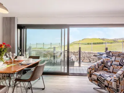 a living room with a table and chairs and a glass door at Goppa in Llanfair