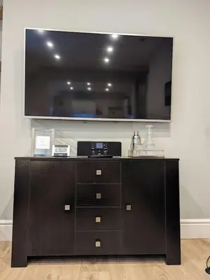 a black dresser with a large mirror on a wall at Pencartref Apartment - 4 Bedrooms, 3 Bathrooms, Sleeps 7-8 in Aberdyfi
